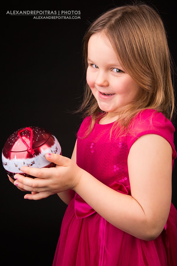 Enfant tenant une boule de Noël rouge dans ses mains